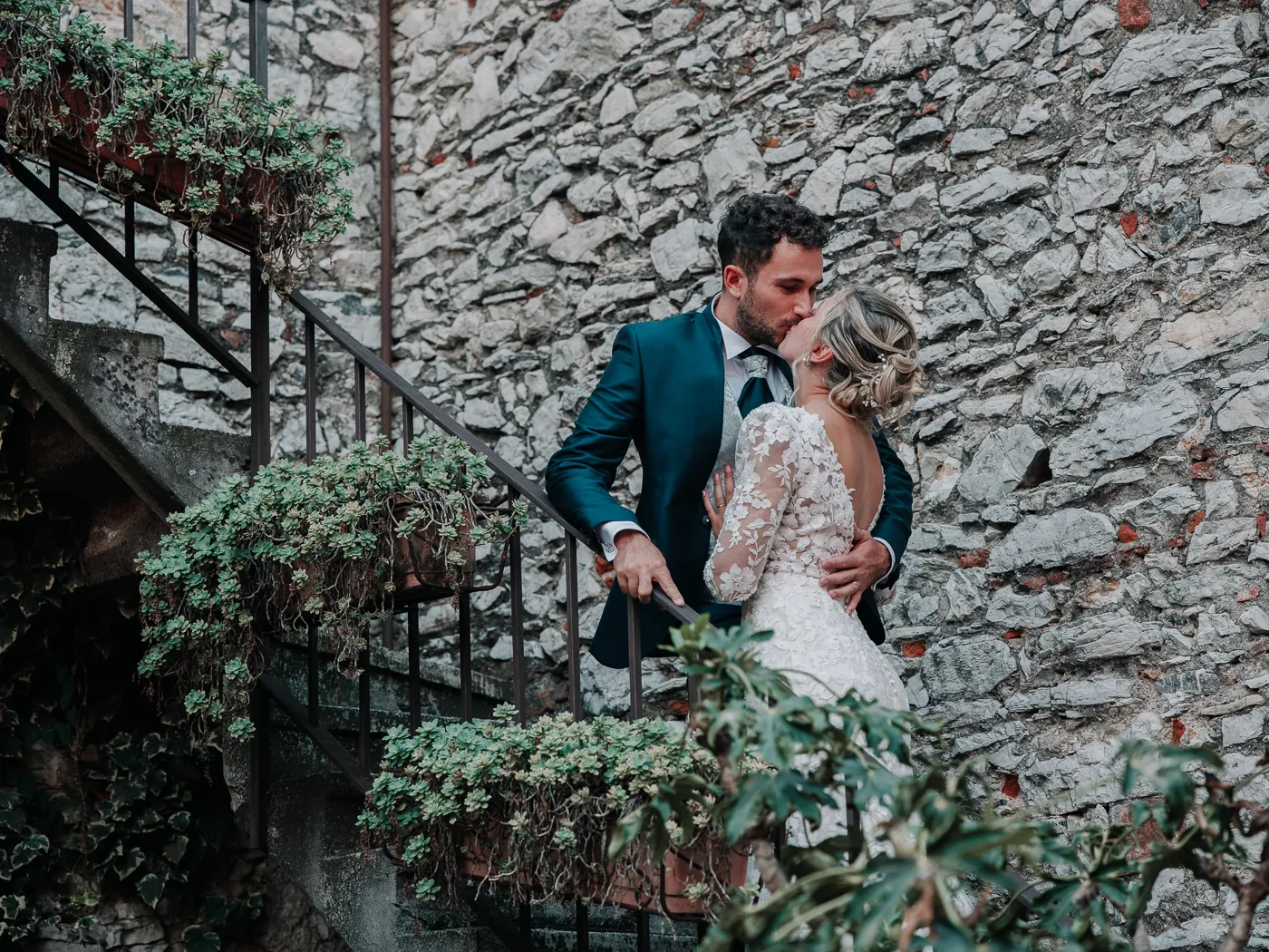 Rossella e Massimo si baciano sulla scala in pietra del Carlo Magno, tra i vasi di fiori, al tramonto